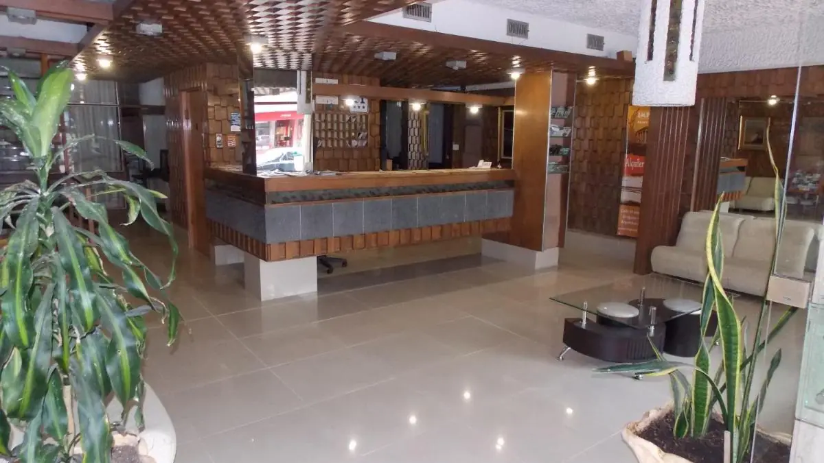 Hotel Shelton的前台,摆有绿植,墙面为木质护板